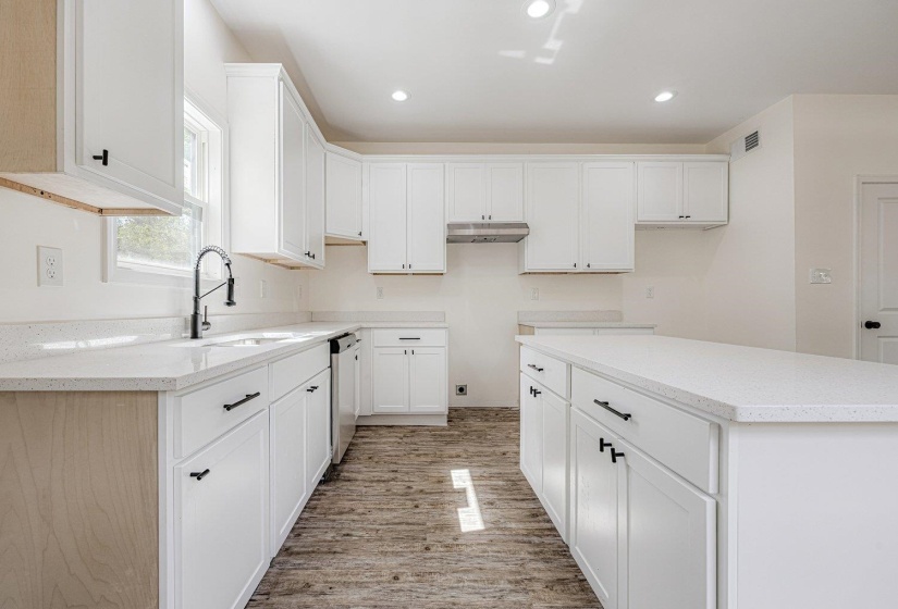 Kitchen with white cabinetry, light stone countertops, and recessed lighting