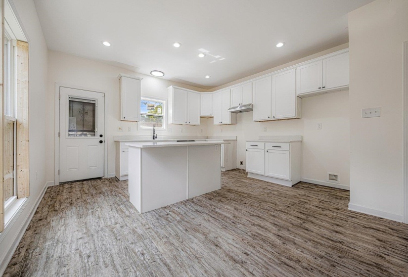 Kitchen featuring white cabinets, a center island, light wood-style flooring, recessed lighting, and light countertops