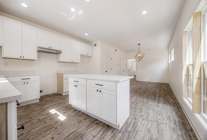 Kitchen with white cabinetry, a center island, recessed lighting, pendant lighting, and under cabinet range hood