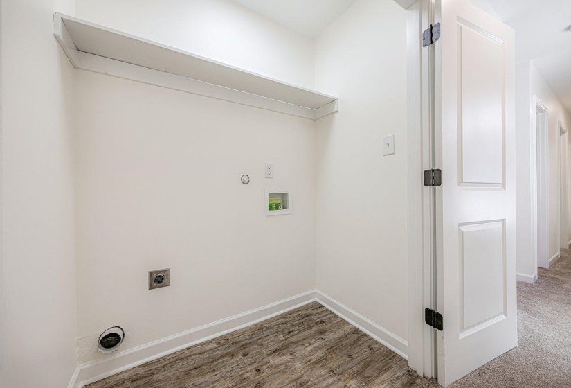 Washroom with hookup for a washing machine, electric dryer hookup, light wood-style flooring, and hookup for a gas dryer