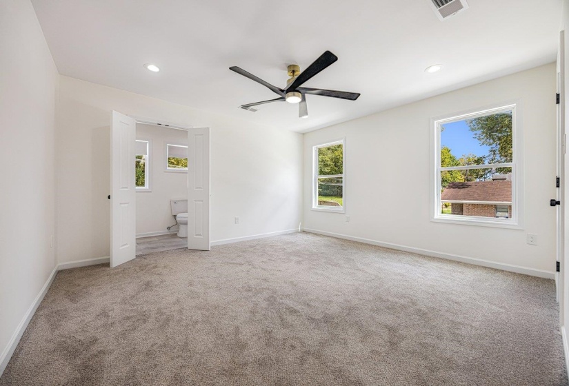 Unfurnished bedroom with light carpet, multiple windows, a ceiling fan, and recessed lighting