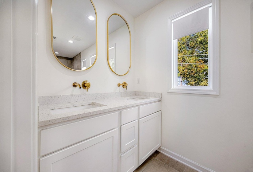 Bathroom with double vanity and light tile patterned floors