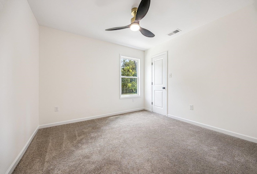 Carpeted empty room with baseboards and a ceiling fan