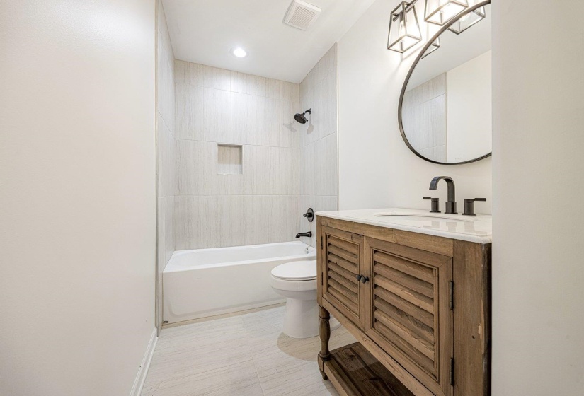 Bathroom with washtub / shower combination, vanity, and recessed lighting