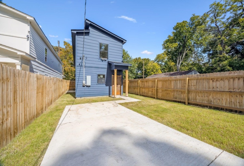 Back of house with a fenced backyard and a patio