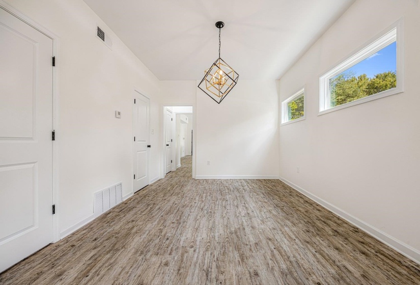Unfurnished dining area with wood finished floors and a chandelier