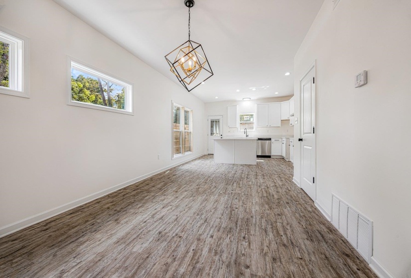 Unfurnished living room featuring recessed lighting, light wood-style flooring, and a chandelier