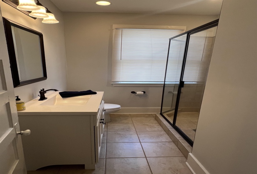 Full bath featuring vanity, a shower stall, light tile patterned floors, and recessed lighting