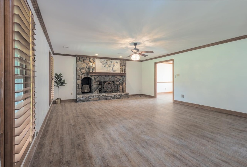 Beautiful stone fireplace with space for wood storage, has wood floors, fresh paint and beautiful new plantation shutters throughout the house.
