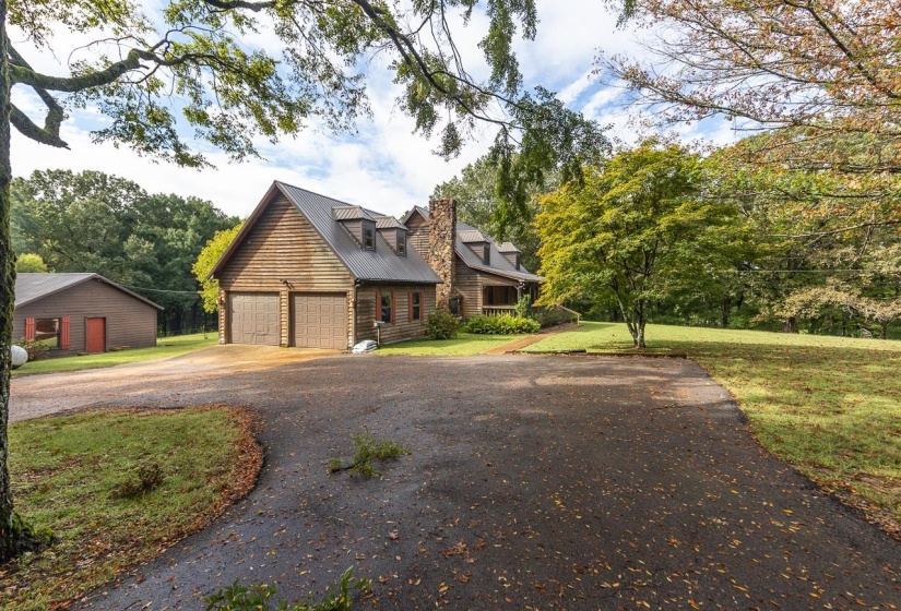 View of front of property featuring a metal roof, a front yard, and driveway