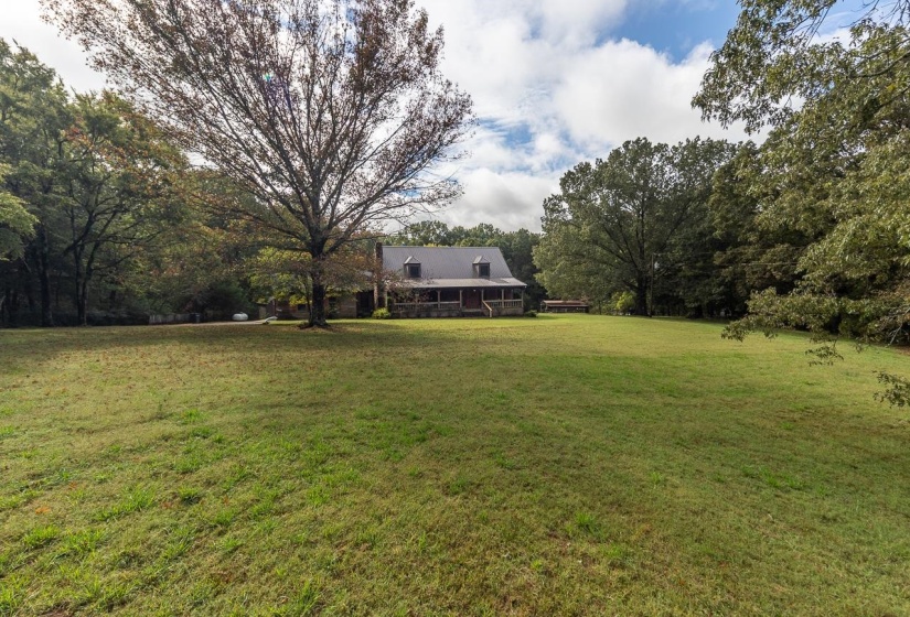 View of grassy yard featuring a deck