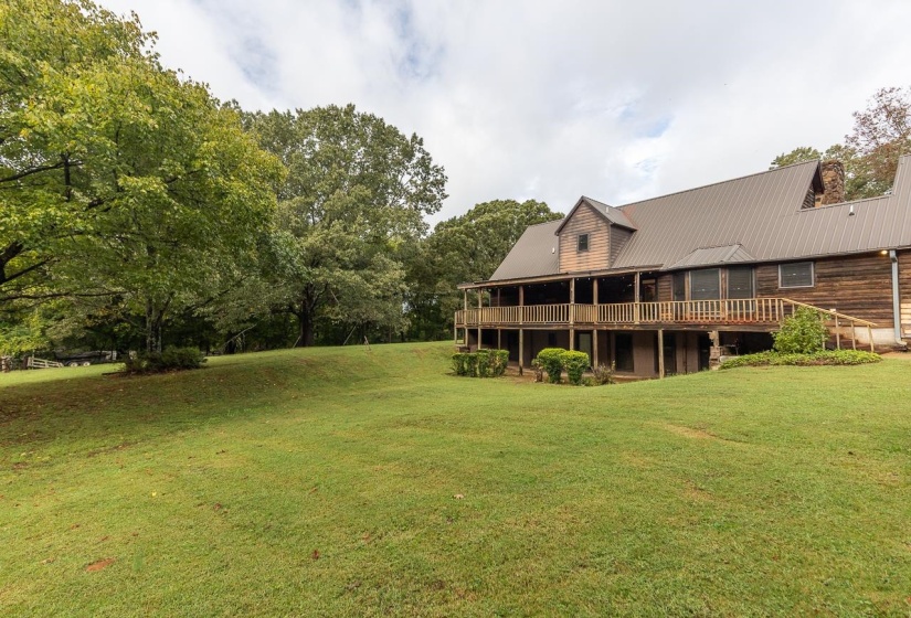 View of green lawn featuring a deck