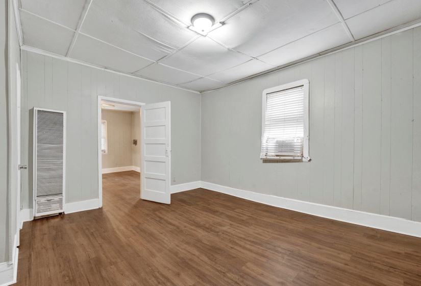 Empty room featuring baseboards, dark wood-style floors, and a heating unit