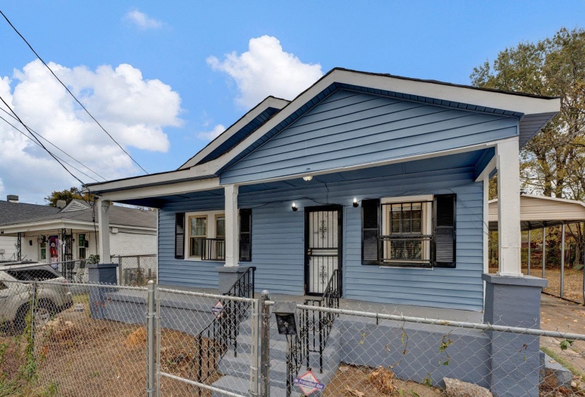View of front of house with a porch, a gate, a carport, and a fenced front yard