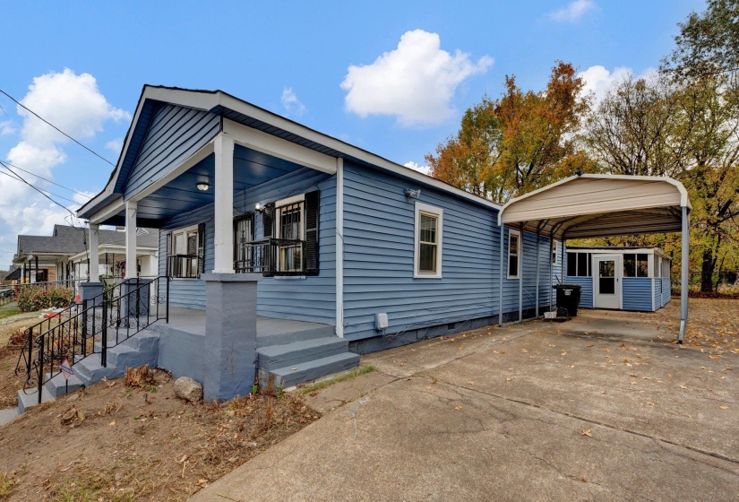 View of side of property featuring a detached carport, a porch, concrete driveway, and crawl space