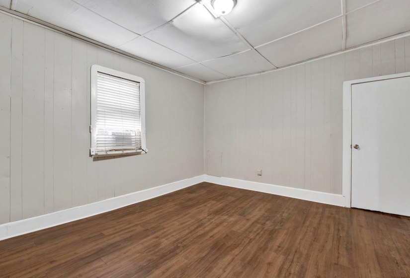 Spare room featuring dark wood-style floors and baseboards