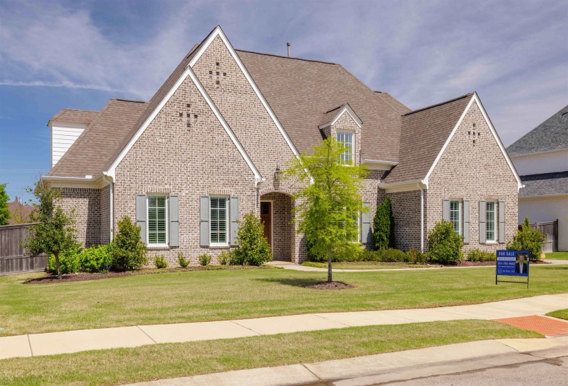 View of front of house with brick siding and roof with shingles