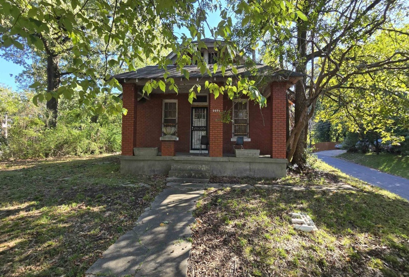 Bungalow with covered porch, brick siding, and a front yard