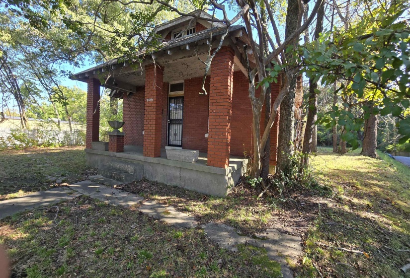 View of front of property with covered porch, brick siding, and a front yard