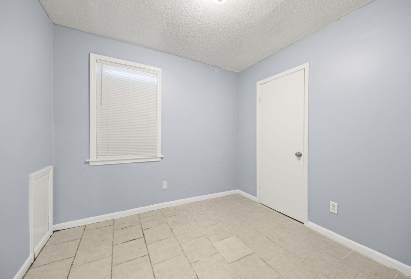 Empty room featuring a textured ceiling and light tile patterned floors