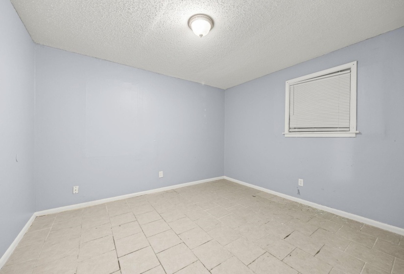 Unfurnished room featuring baseboards and a textured ceiling