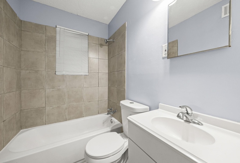 Full bathroom with washtub / shower combination, a textured ceiling, and vanity
