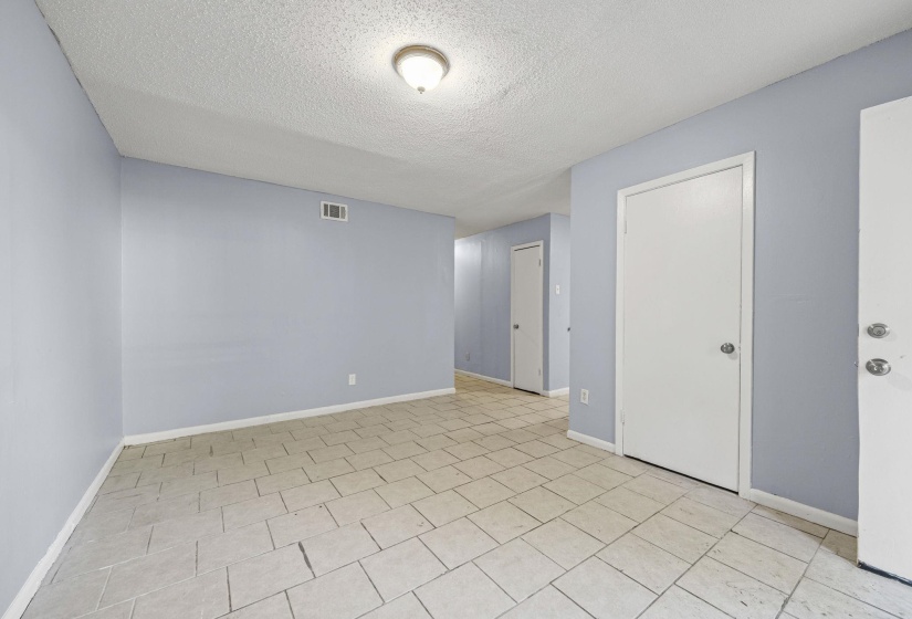 Spare room with a textured ceiling and light tile patterned floors