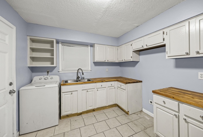 Laundry room featuring washer / clothes dryer, a textured ceiling, and light tile patterned floors