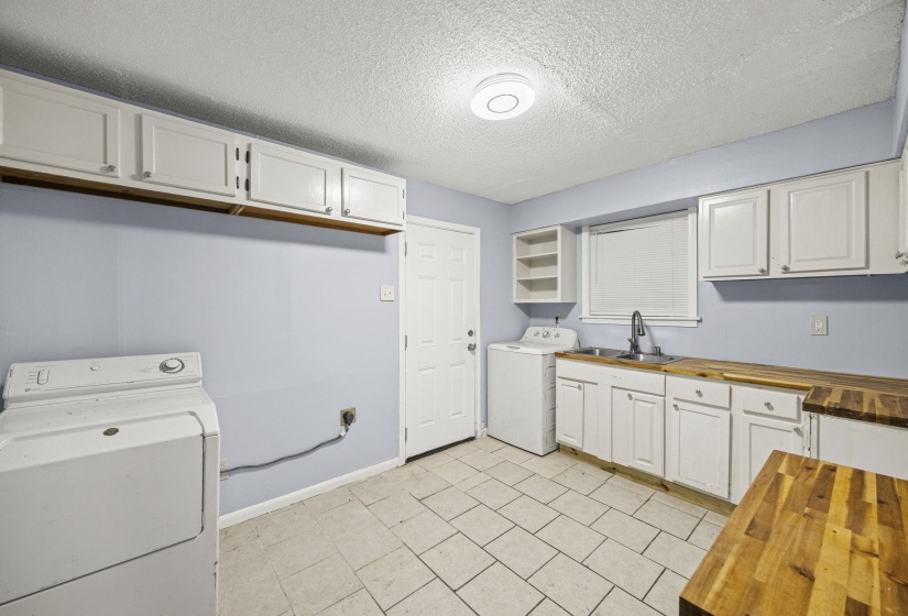 Laundry room with washer / clothes dryer, a textured ceiling, and light tile patterned floors
