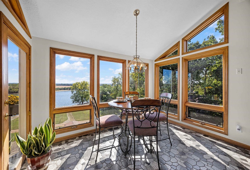 Sunroom featuring a water view, vaulted ceiling, and a chandelier