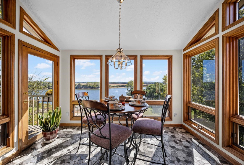 Sunroom featuring vaulted ceiling, a water view, and a chandelier