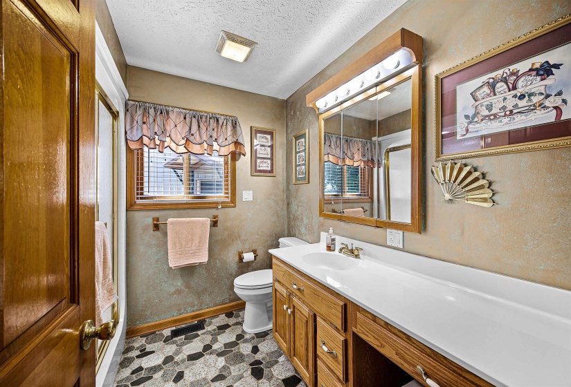 Bathroom with a textured ceiling, vanity, and an enclosed shower