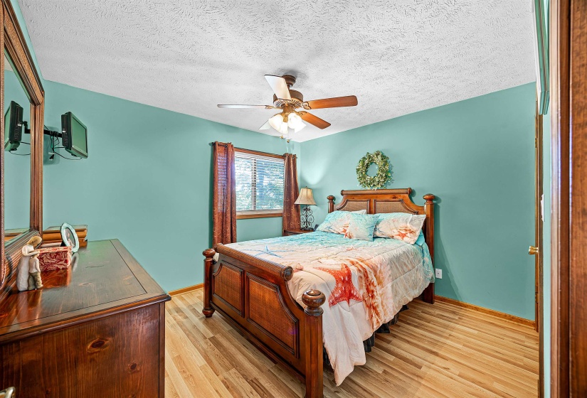 Bedroom featuring light wood-style floors, a textured ceiling, and ceiling fan