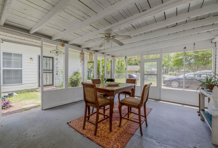 Sunroom / solarium featuring outdoor dining area, ceiling fan, and beamed ceiling