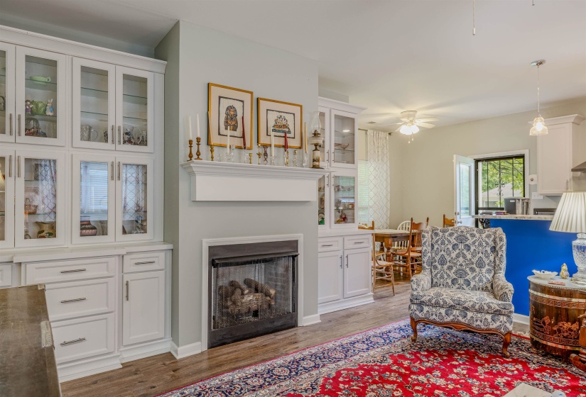 Living room featuring light wood-type flooring, a fireplace, and a ceiling fan