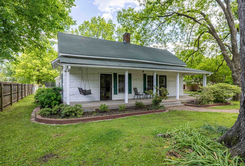 Back of property with a chimney, roof with shingles, and covered porch