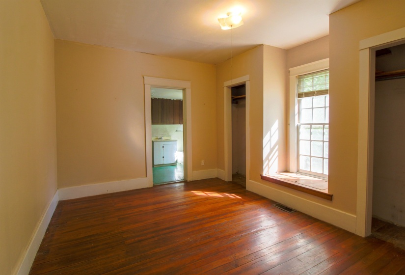 Bedroom featuring original hardwood floors and two closets
