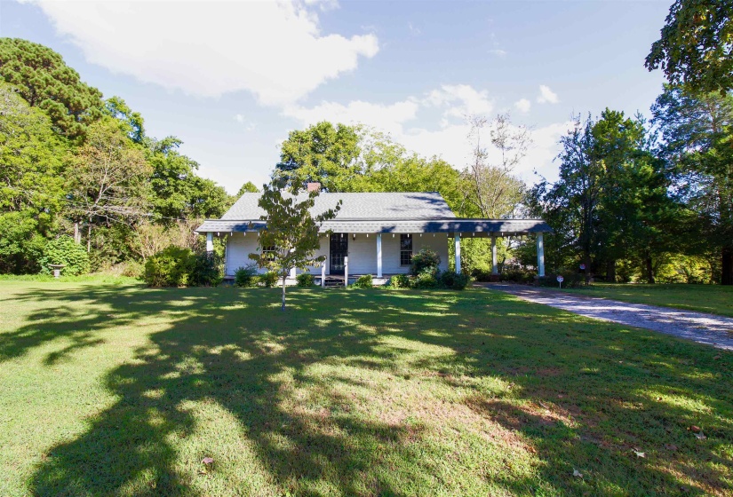 View of front of house with a  covered porch, an attached carport, a front yard, and driveway