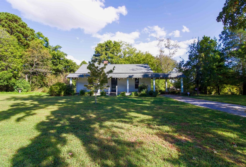 View of front of home featuring a  covered porch, a carport, a front yard, and driveway