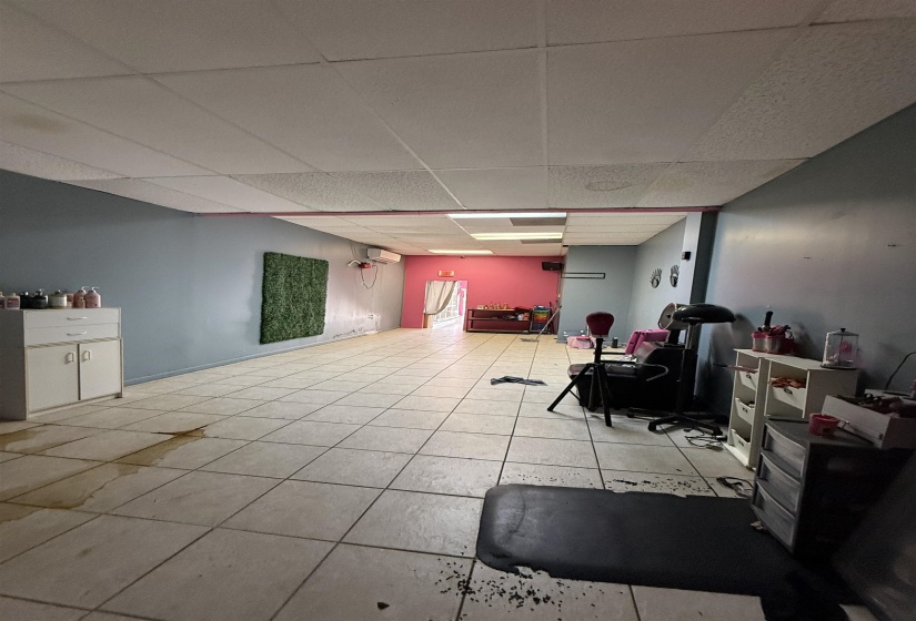 Below grade area featuring a drop ceiling and light tile patterned flooring