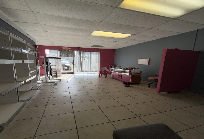 Basement with a drop ceiling and light tile patterned flooring