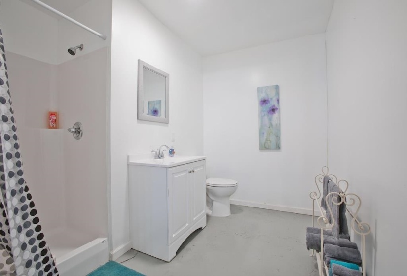 Full bathroom featuring concrete flooring, a stall shower, and vanity