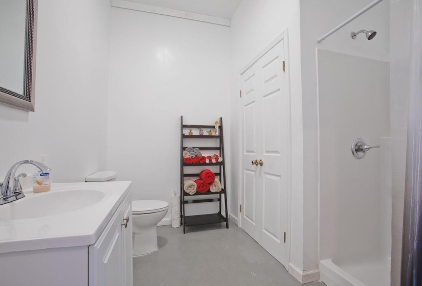 Bathroom featuring a shower stall, concrete floors, and vanity
