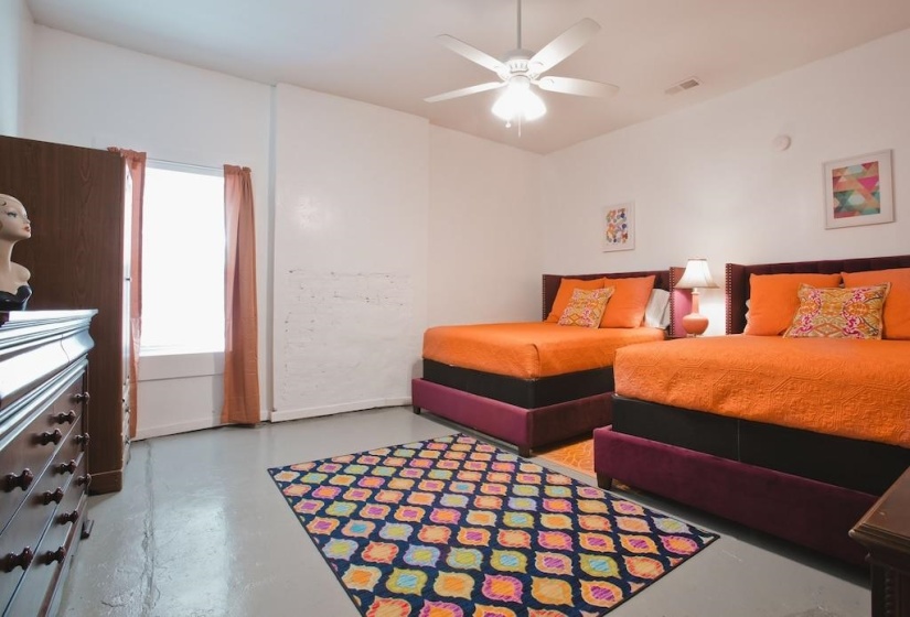 Bedroom featuring finished concrete floors and a ceiling fan