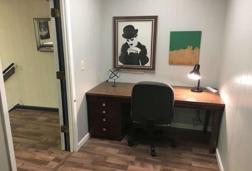 Home office with dark wood-style floors and wood walls