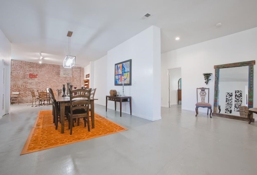 Dining area with brick wall and finished concrete floors