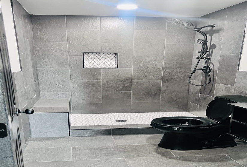 Bathroom with a shower stall and tile patterned floors
