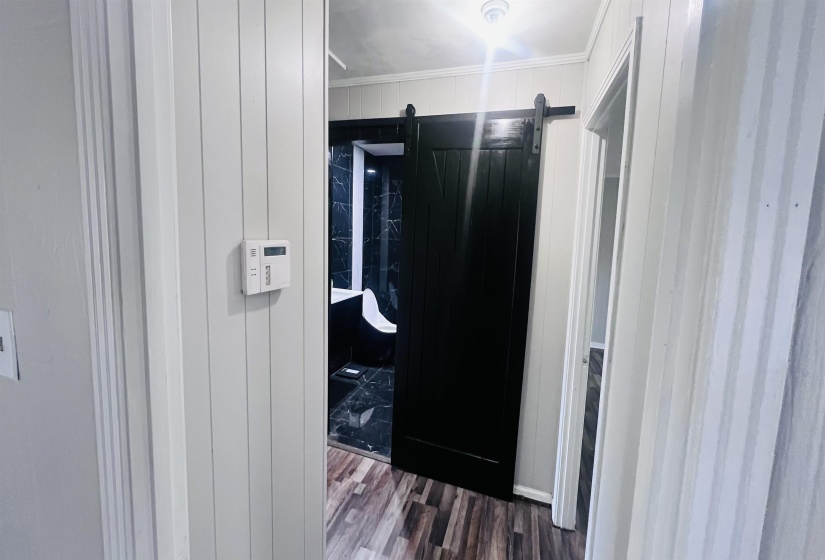 Bathroom with wood finished floors and wooden walls