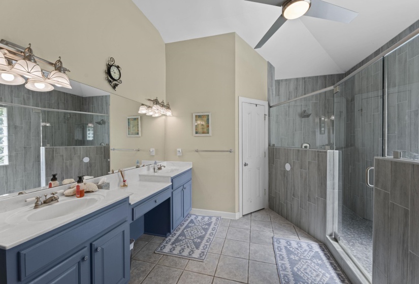 Bathroom with tile patterned flooring, double vanity, a ceiling fan, a sink, and a stall shower