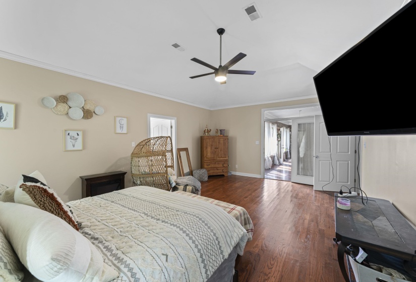 Bedroom with dark wood-type flooring, visible vents, a ceiling fan, and ornamental molding